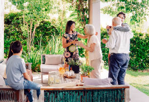 Happy family greeting each other in patio. Happy males and females are celebrating weekend party at patio.