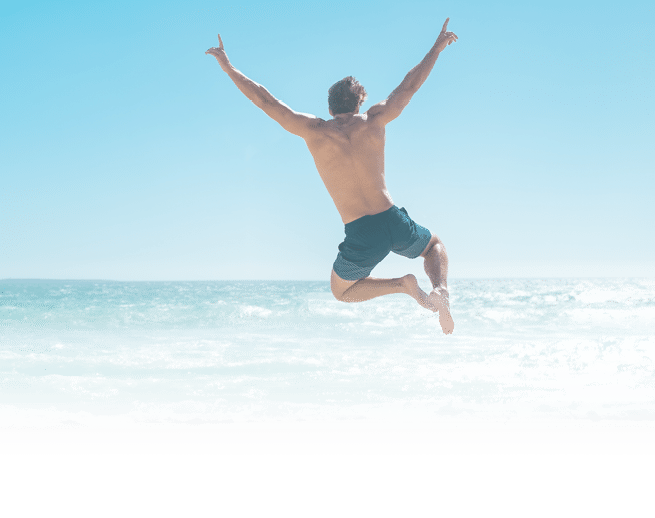 Une personne en short saute joyeusement au-dessus de la plage avec les bras lev s sous un ciel bleu clair. Description g n r e par IA