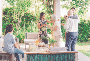Happy family greeting each other in patio. Happy males and females are celebrating weekend party at patio.