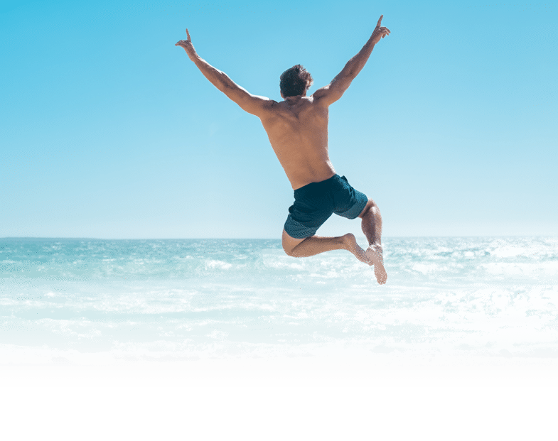 Une personne en short saute joyeusement au-dessus de la plage avec les bras lev s sous un ciel bleu clair. Description g n r e par IA