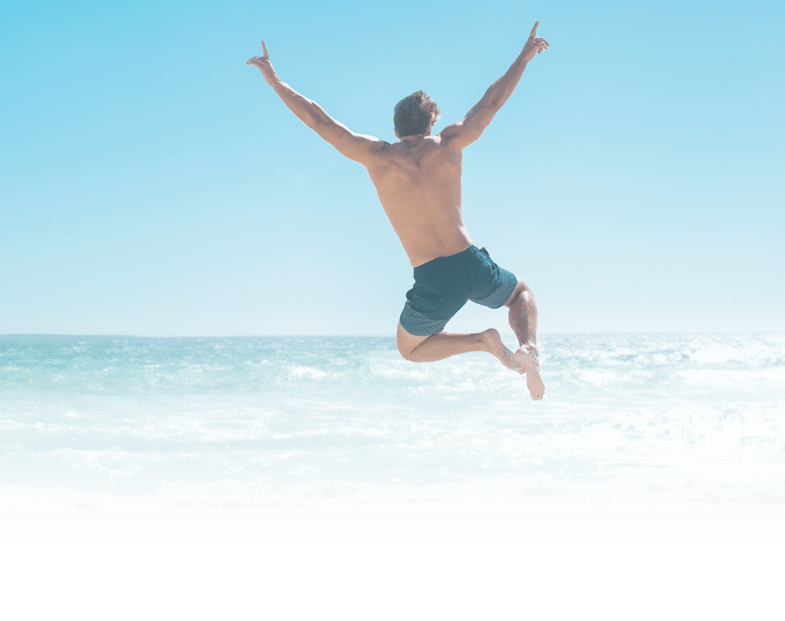 Une personne en short saute joyeusement au-dessus de la plage avec les bras lev s sous un ciel bleu clair. Description g n r e par IA
