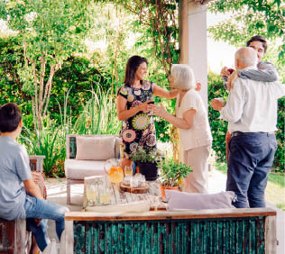 Happy family greeting each other in patio. Happy males and females are celebrating weekend party at patio.