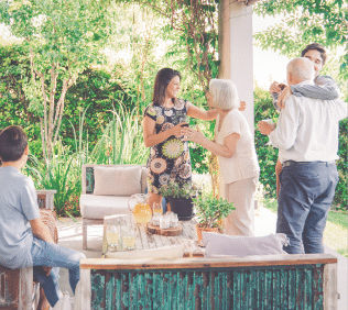 Happy family greeting each other in patio. Happy males and females are celebrating weekend party at patio.